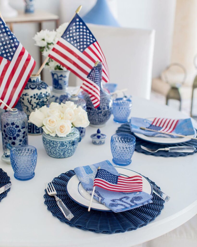 table with blue and white place setting and american flags