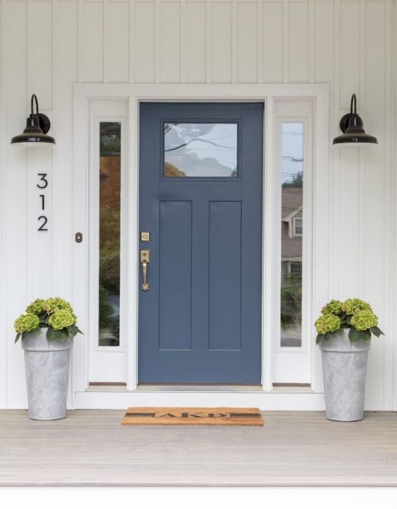 Image of blue front door with industrial porch lighting.