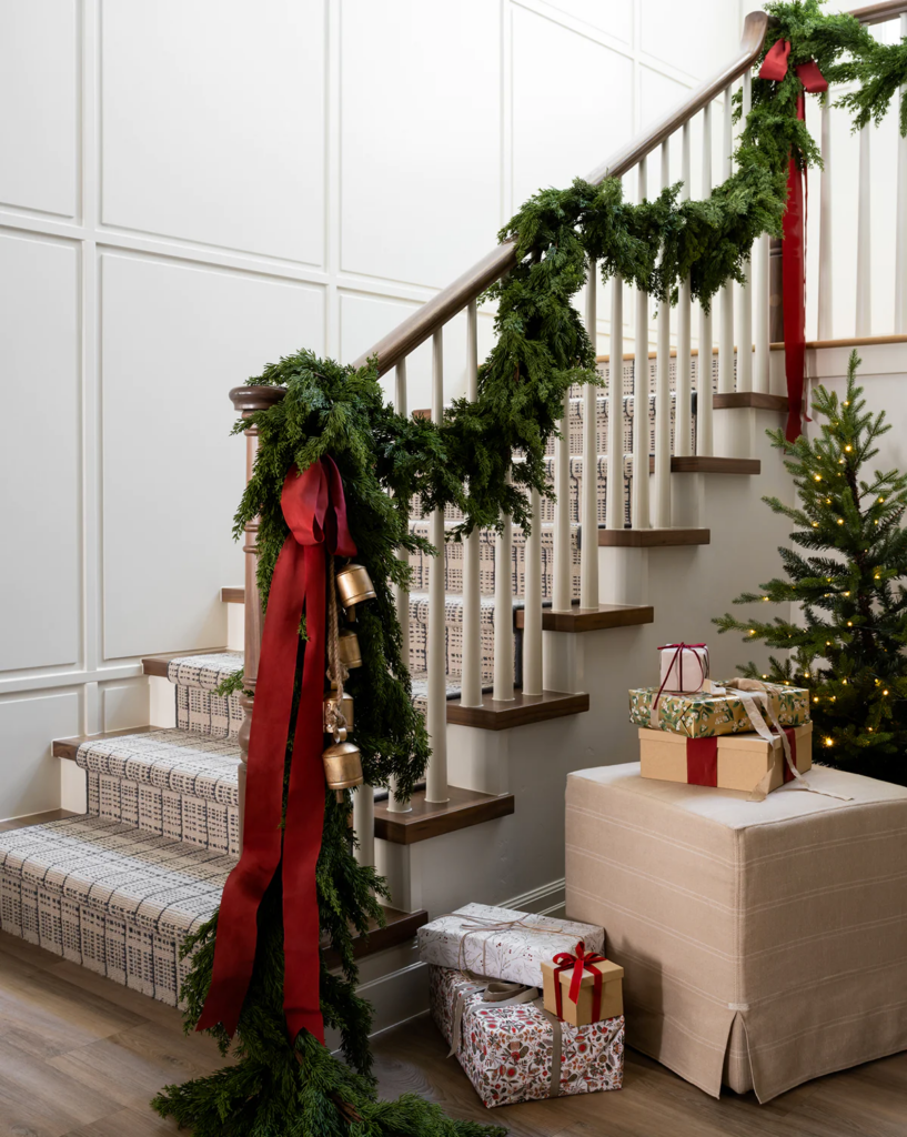 Christmas staircase decor, hanging garland and red velvet ribbon