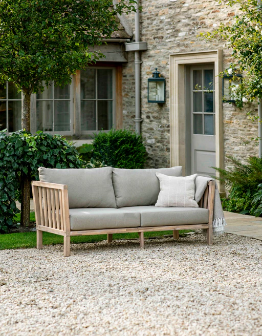 english outdoor garden with outdoor patio sofa, gray cushions