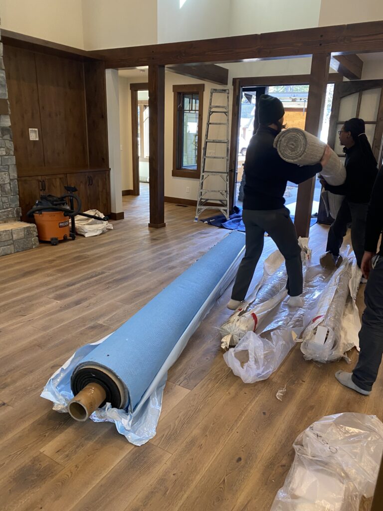 Men installing rugs in a suncadia mountain vacation home for Michelle Yorke Interior Design